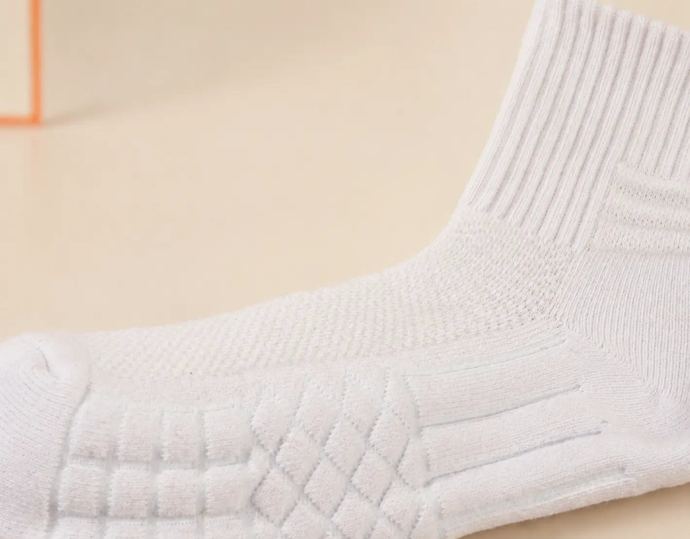 Real side-angle close-up of the D7 Ankle sock showing instep knit and zoned cushioning, with a lab background